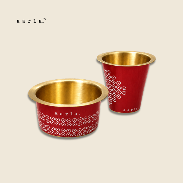 Aarla Red Kolam brass dabara tumbler set on beige background